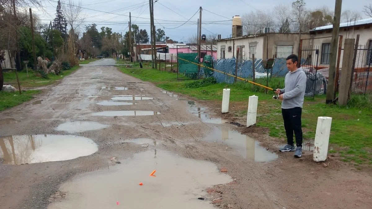 Un vecino de Villa Elvira salió a "pescar" en un bache: el insólito reclamo por una calle olvidada