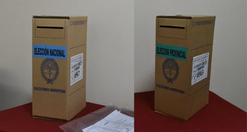 Urna con cartel celeste para la boleta única con oferta electoral nacional y otra, con la oferta a cargos provinciales.  