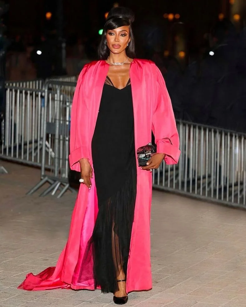 Naomi Campbell luci&oacute; un vestido lencero con una bata de tafet&aacute;n rosa fuerte.